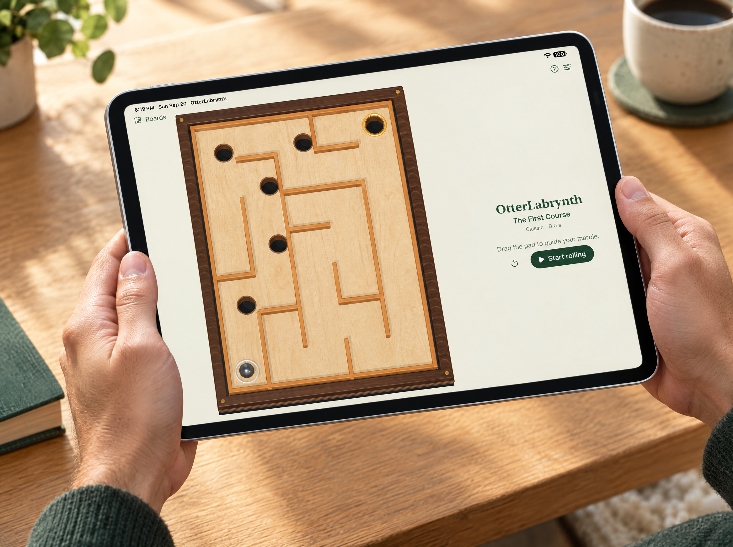 Hands holding an iPad with OtterLabrynth’s wooden maze